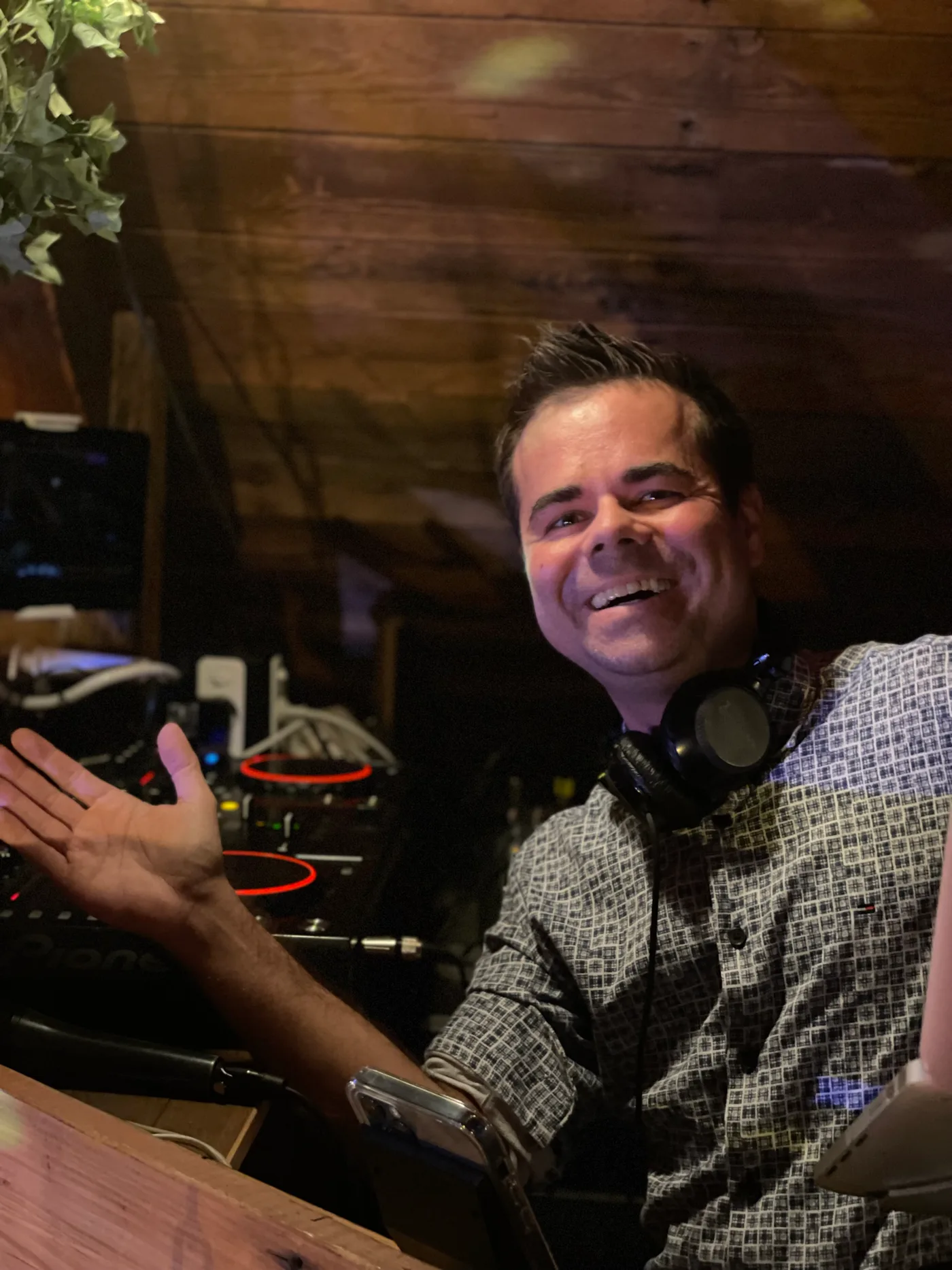 DJ Bonzay live in einer Location mit Holzambiente, Kopfhörer um den Hals